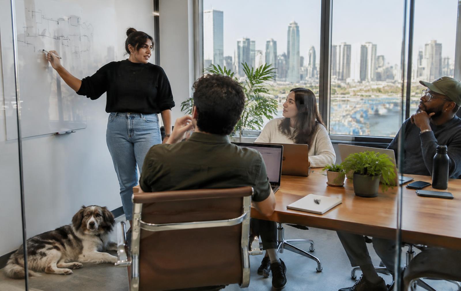 A hiring team discussing open roles in a glass meeting room in Austin